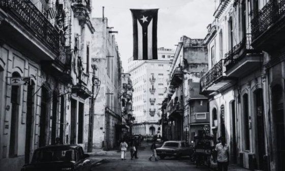 Bandera cubana colgada en medio de una calle habanera.