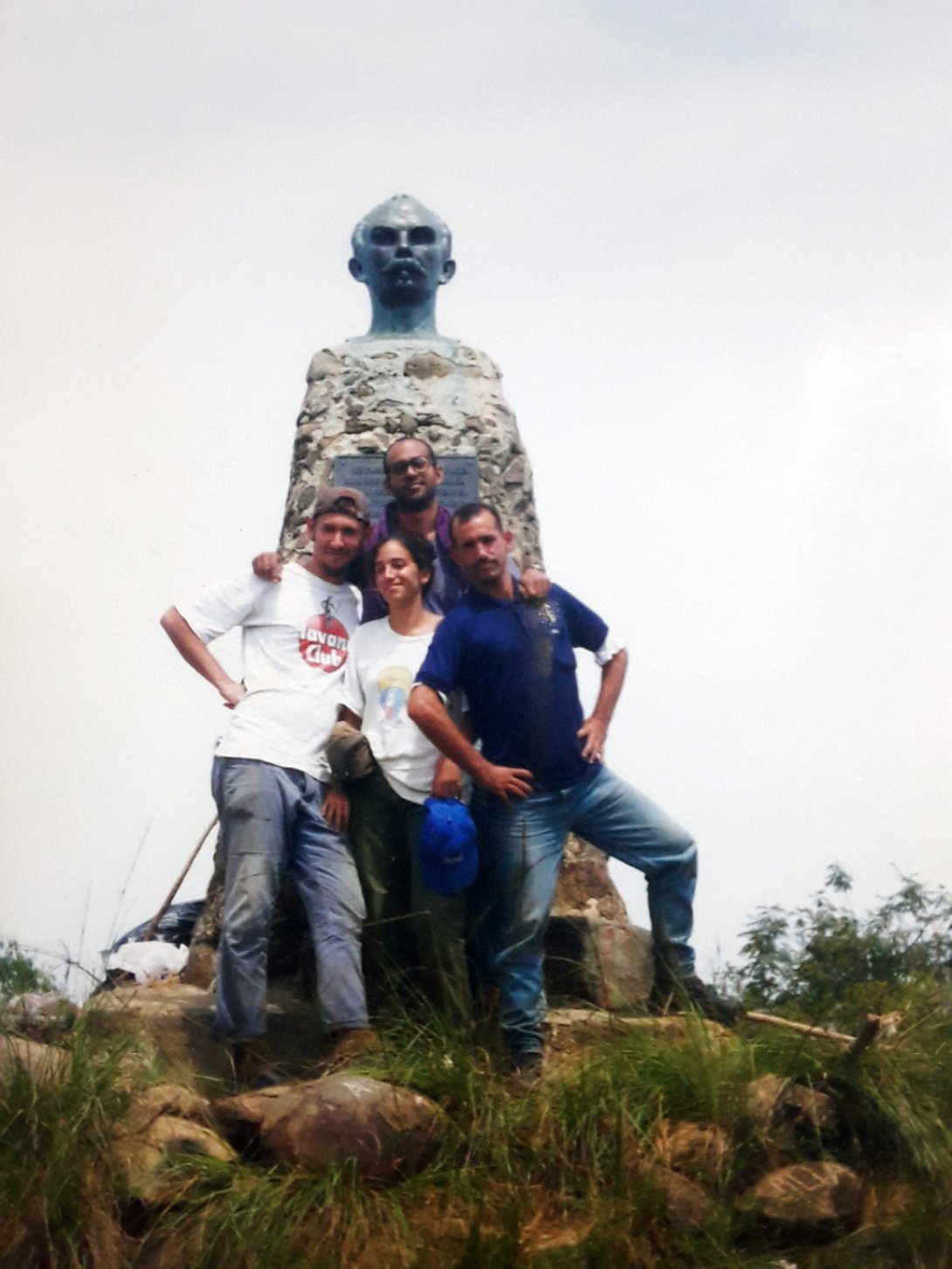Amilkar Feria junto con sus primos, ante el busto de José Martí en el Pico Turquino.