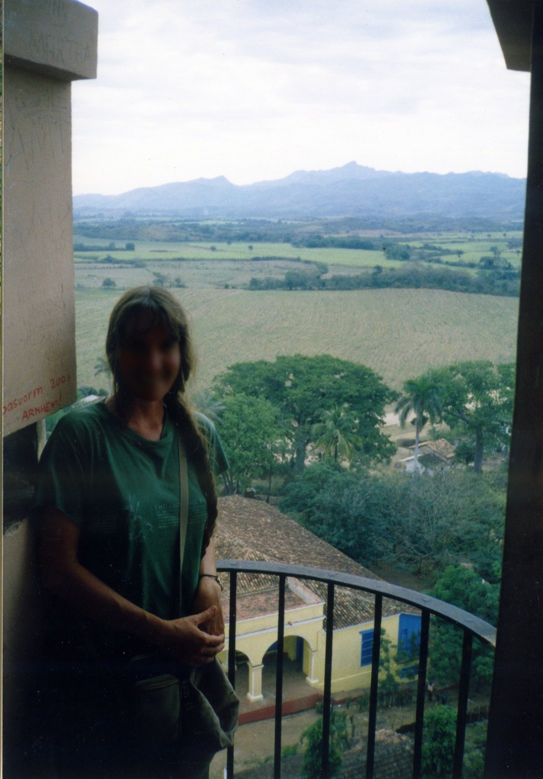7-Svetlana en uno de los niveles de la torre de Iznaga. Al fondo, la casa de vivienda de la hacienda, una panorámica de El Valle de los Ingenios, y el Pico de Potrerillo.La Pastora. 