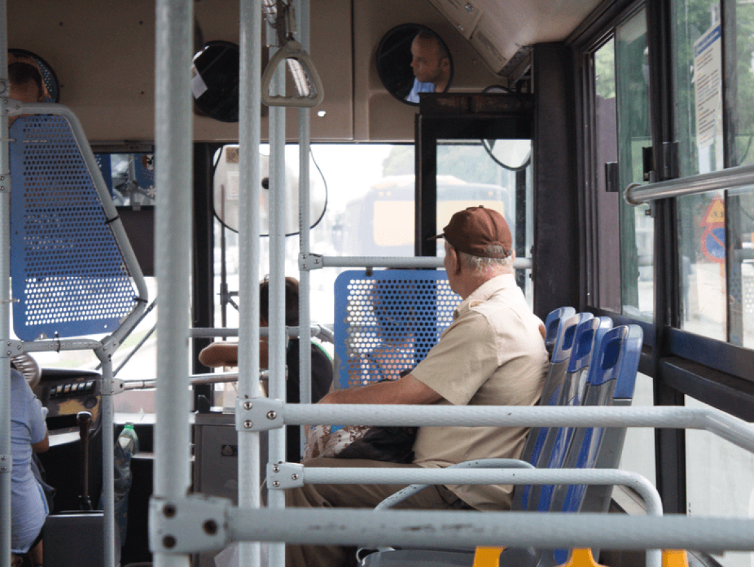 Persona en Cuba sentada en el transporte público observa la ciudad a través de las ventanillas.