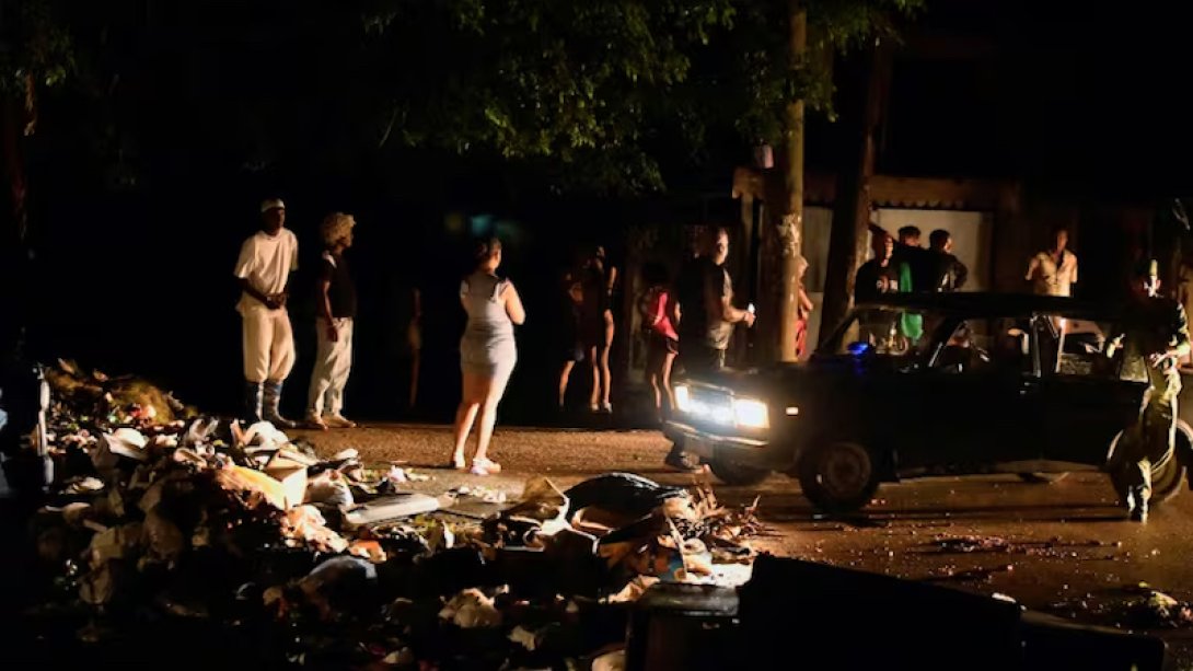 Cubanos en una calle llena de basura durante el apagón.