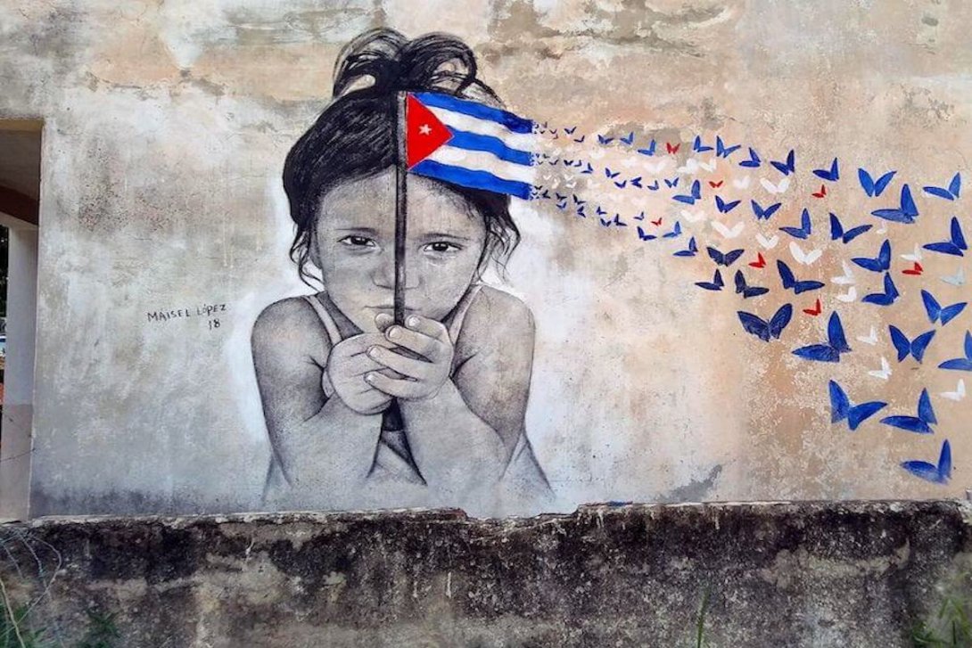 Obra de Maisel López en una calle de La Habana, niña sosteniendo una bandera cubana