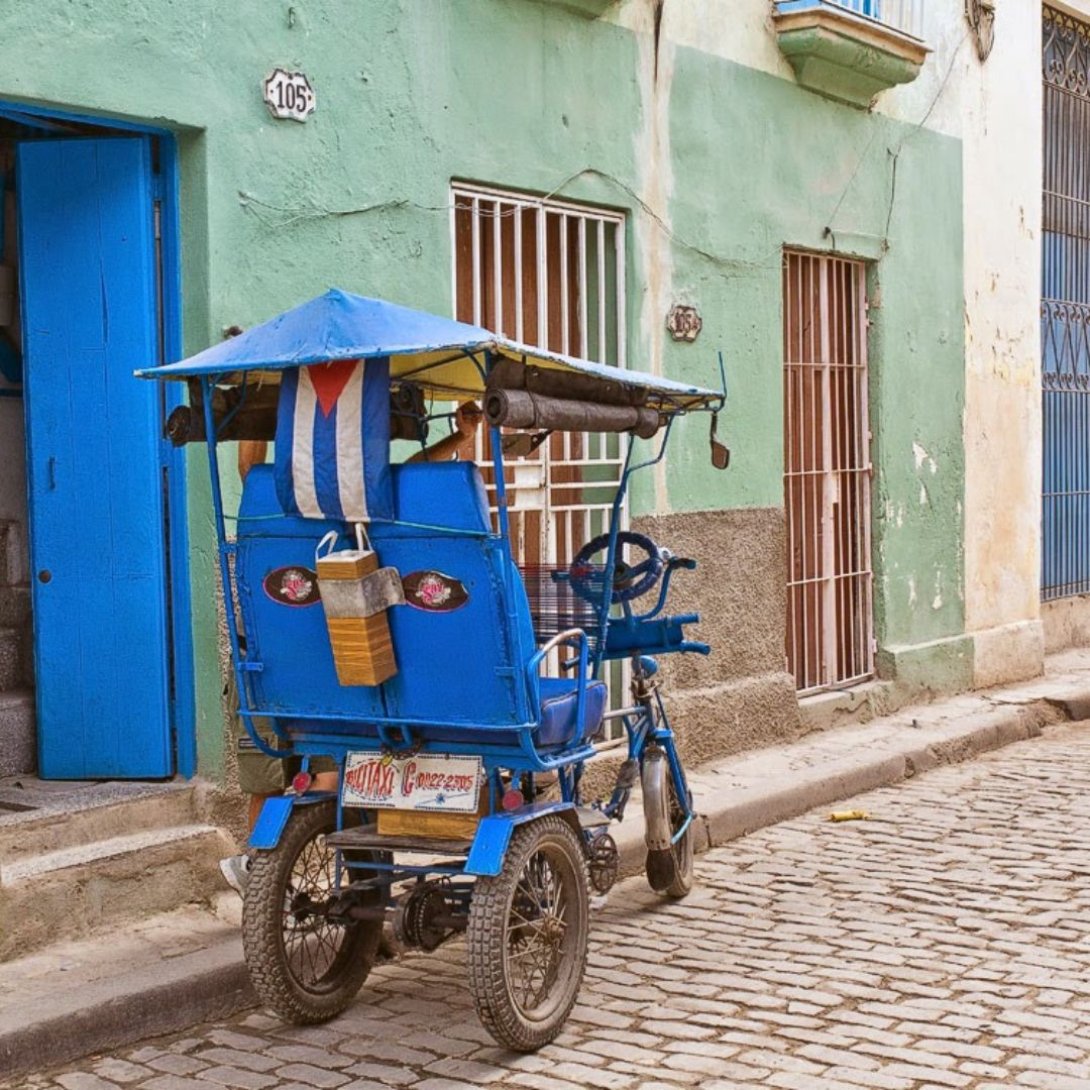 Vehículo artesanal de tres ruedas conocido como bicitaxi, utilizado para transportar personas en ciudades cubanas con limitado acceso a transporte.