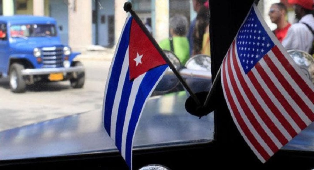 Banderas de Cuba y Estados Unidos en interior de un auto en Cuba