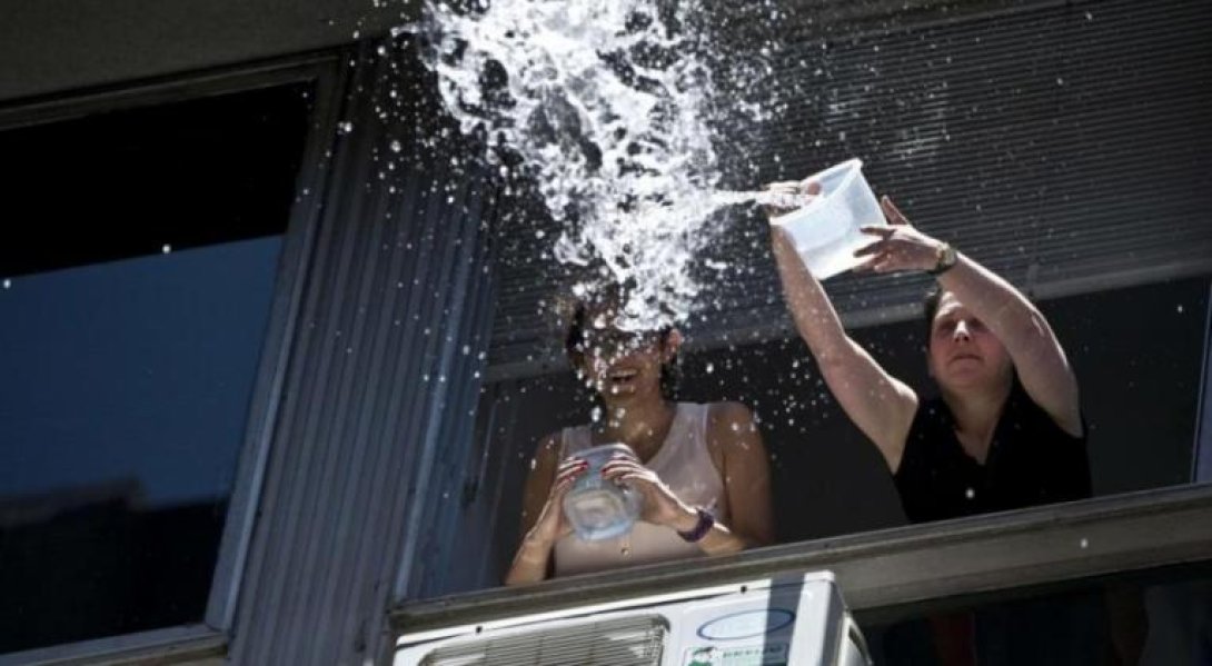 Cubanas lanzan un cubo de agua desde el balcón.