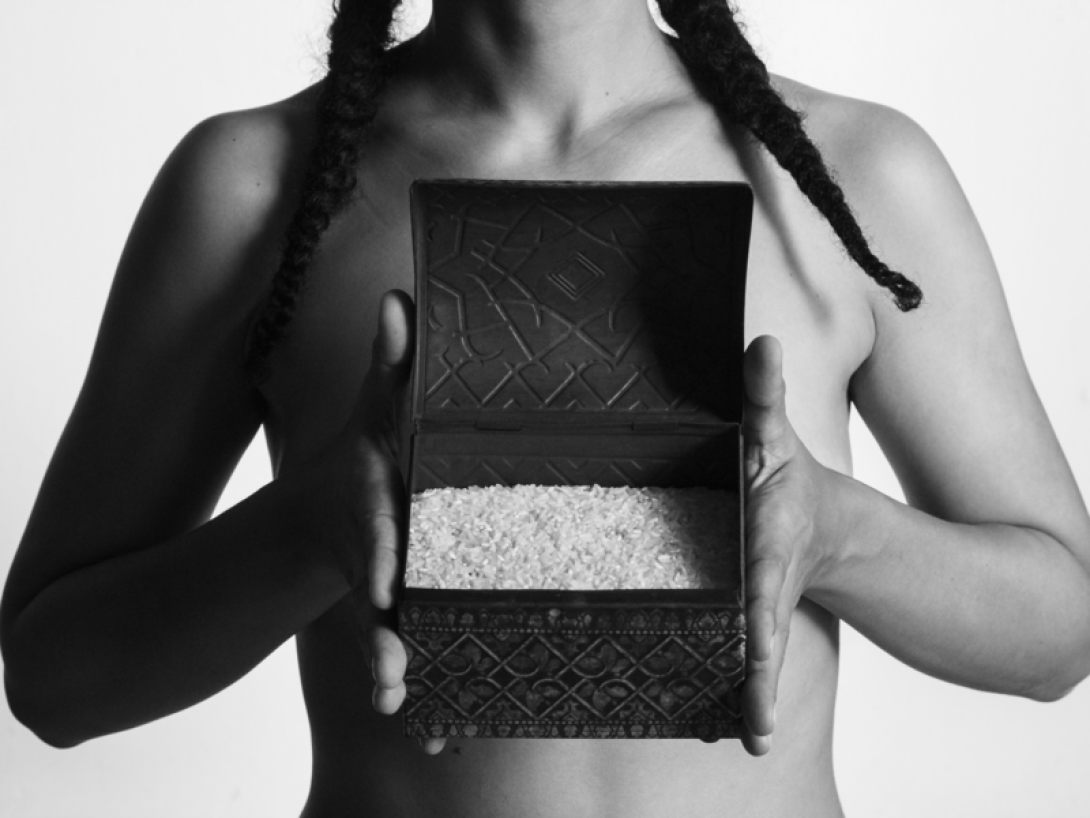 Torso femenino sosteniendo caja con arroz.