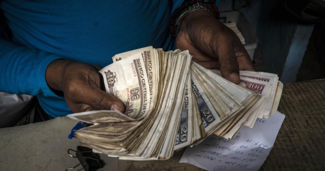 Una persona sostiene un manojo de billetes de pesos cubanos