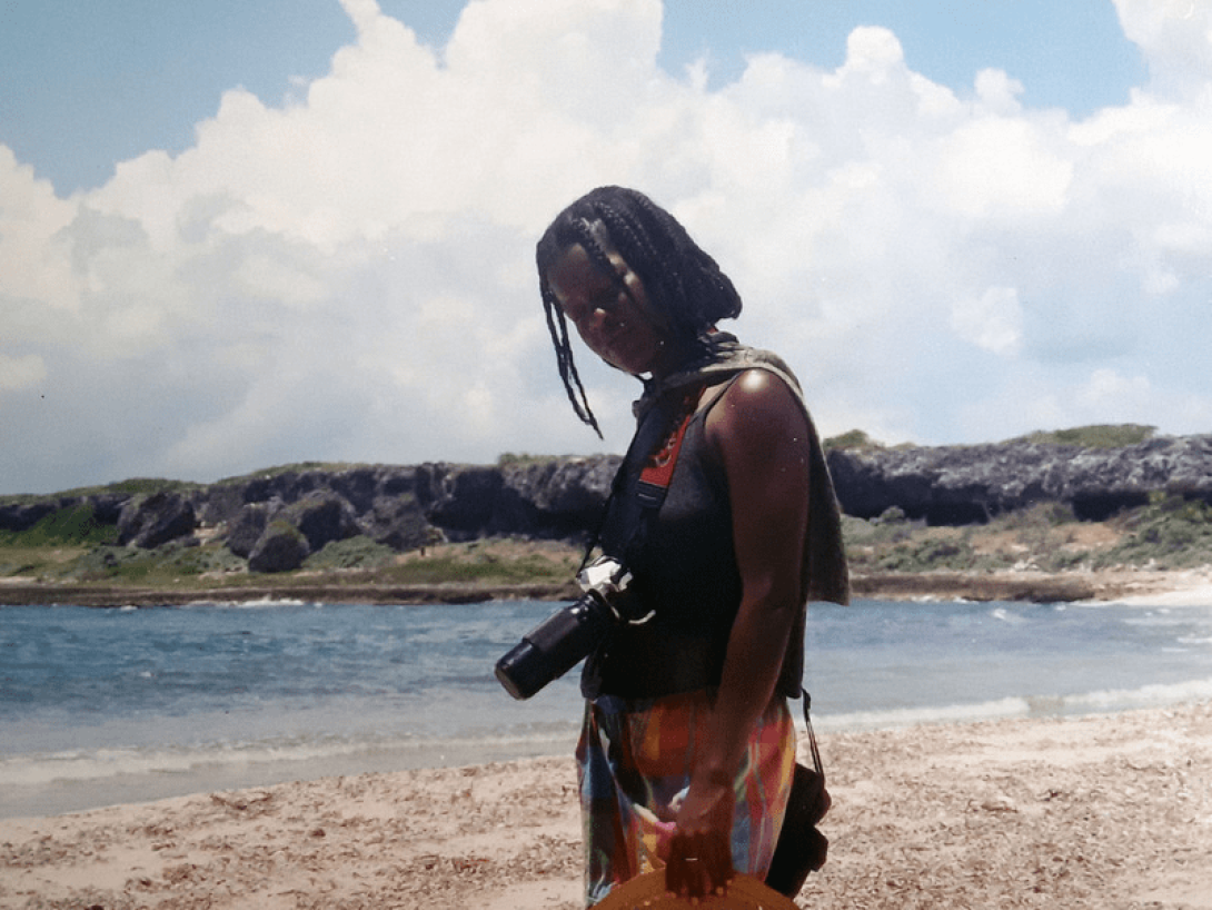 Mujer con cámara fotogrñafica en la playa.