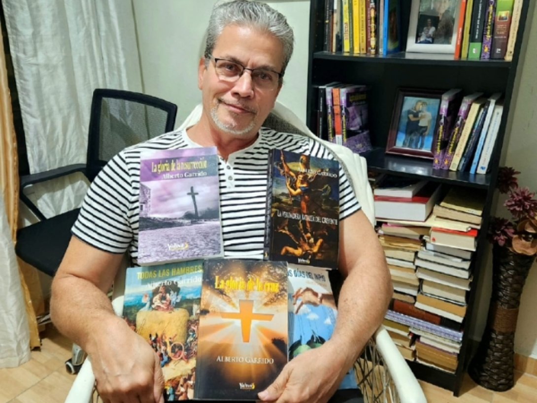 Escritor cubano Alberto Garrido con varios de sus libros.