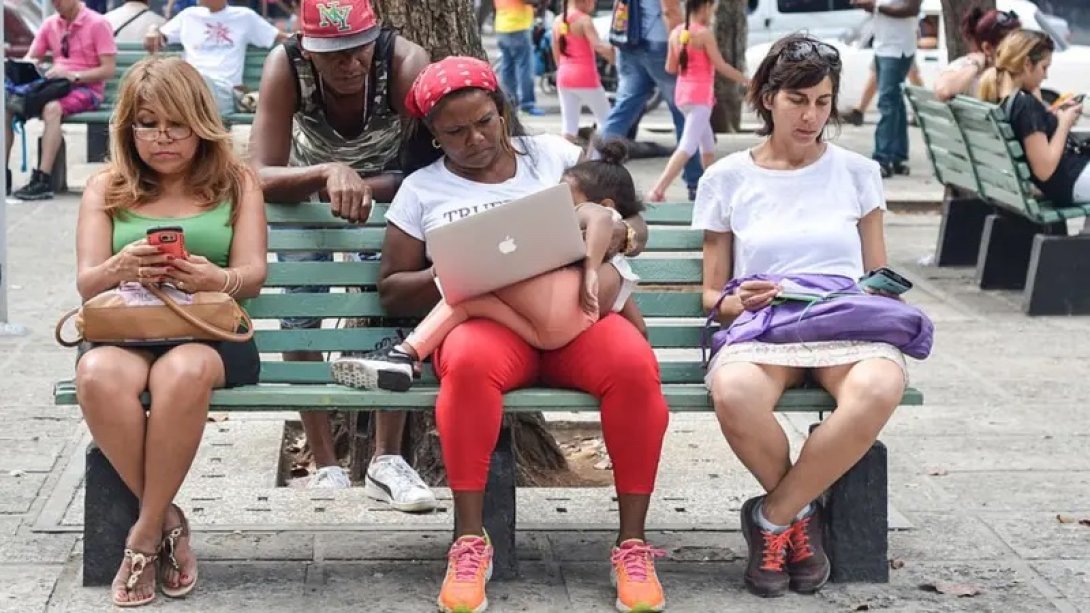 Cubanas conectadas a internet en una plaza pública.