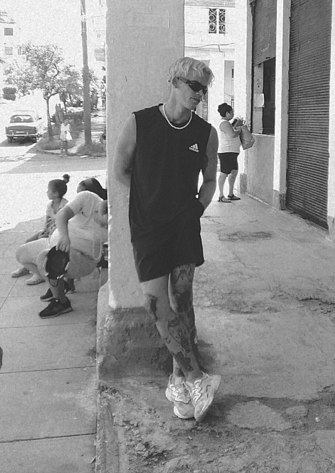 Un joven cubano recostado a una columna.