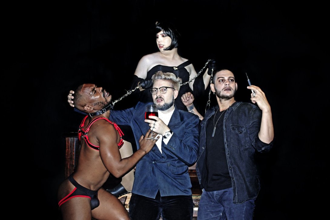 cuatro actores en escena vestidos al estilo sadomasoquista