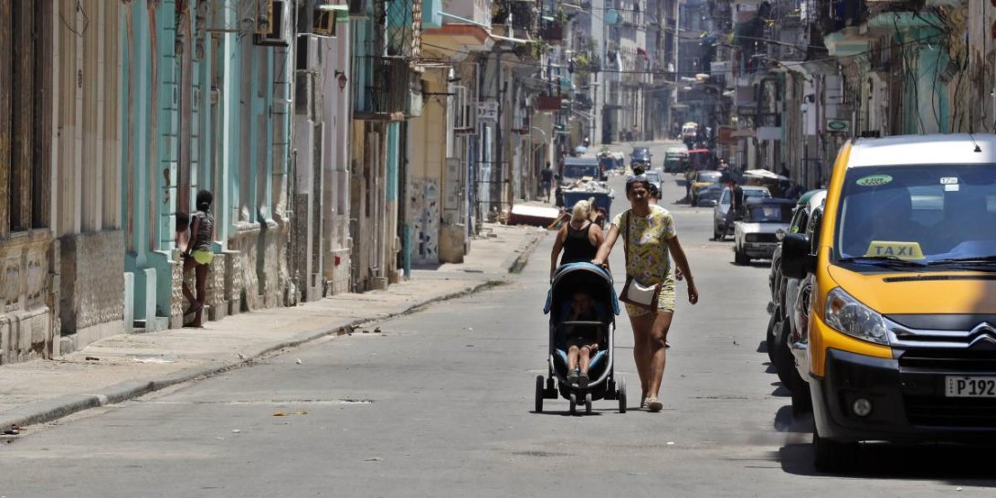 Una mujer camina por una calle en Cuba.