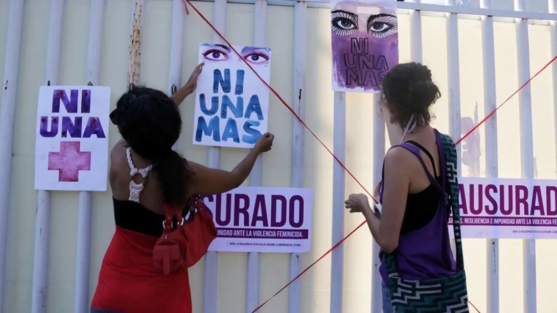 Mujeres pegando feministas en la pared carteles.