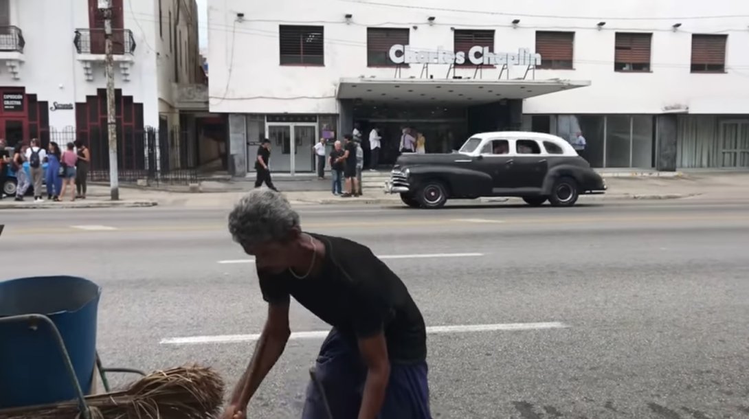 Hombre limpiando la calle frente al cine Charles Chaplin