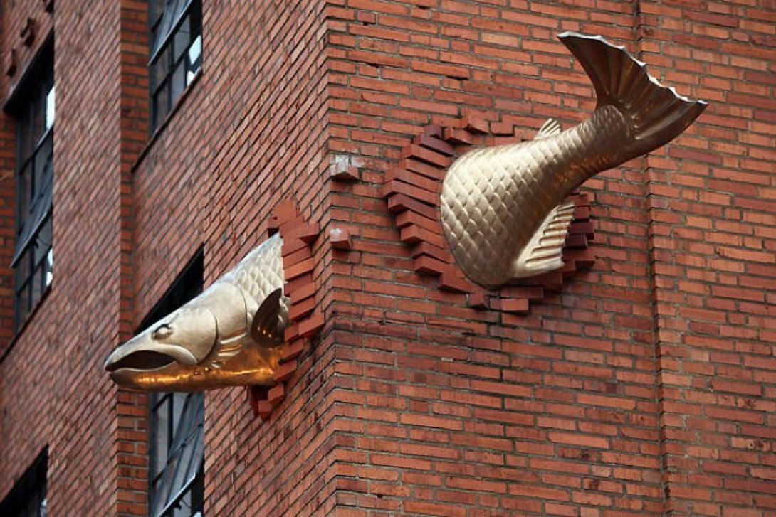 Escultura arte urbano "Trascendence", de Keith Jellum, pez "atravesando" edificio