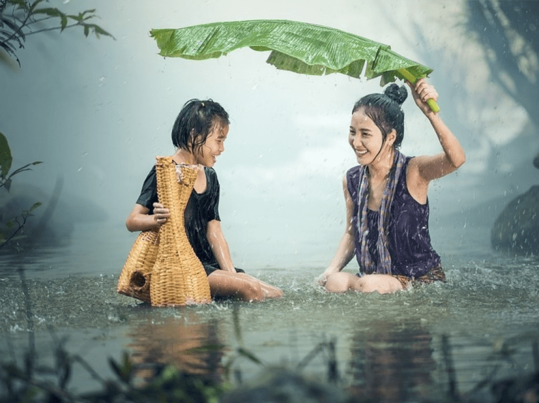 Una mujer y una niña en un lago en la naturaleza mientras llueve.