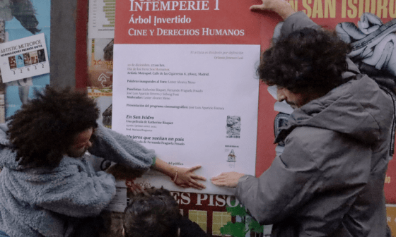 Yanelis Núnez y Julio Llópiz Casal pegando el cartel del Foro Intemperie.