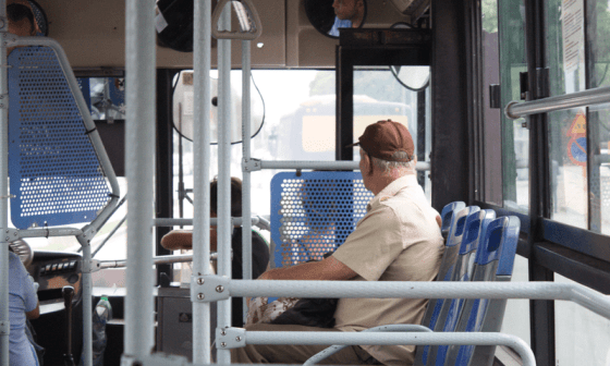 Persona en Cuba sentada en el transporte público observa la ciudad a través de las ventanillas.