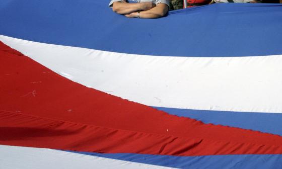 Hombre apoyado en la bandera cubana