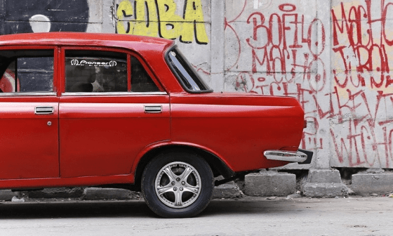 Carro antiguo soviético junto a pared con graffittis.