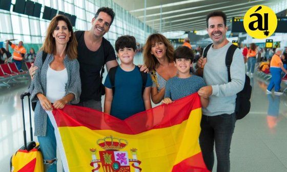 Familia de españoles emigrantes que regresan con bandera española en aeropuerto
