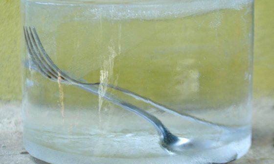 Un tenedor y una cuchara dentro de un bloque de hielo.
