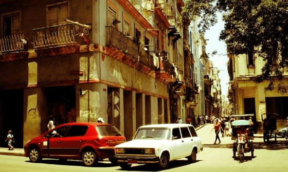Vista de una calle de Cuba con autos y edificios antiguos.