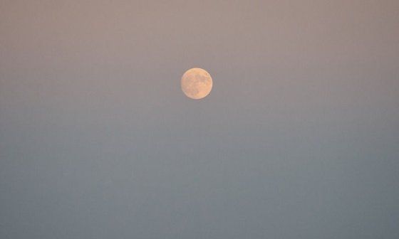 Luna llena sobre el mar en la tarde.