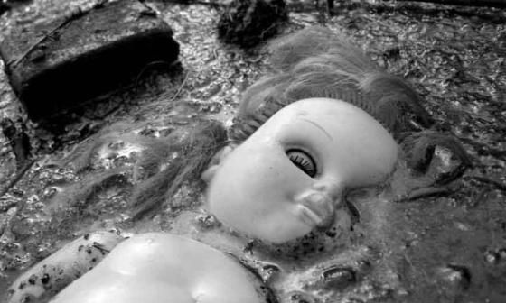 Muñeca hundida en el fango