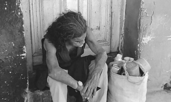 Una mujer sentada delante de una puerta con expresión de cansancio.