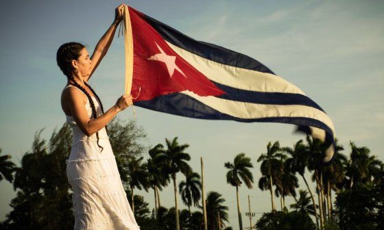 La artista Nany sostiene la bandera cubana mientras ondea
