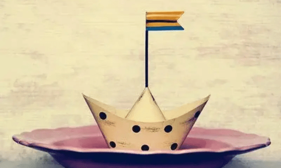 Barco de papel sobre un plato.