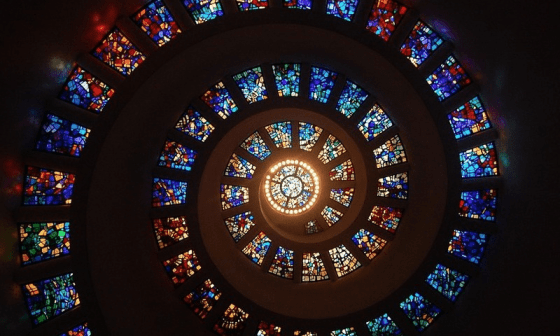 Cristales con vitrales a través de los que entra la luz forman en conjunto una espiral.