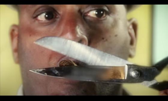 Trovador cubano Fernando Bécquer fuma un tabaco mientras una tijera corta al mismo.