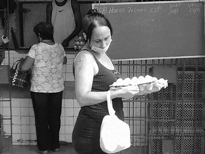 Mujer sostiene un cartón de huevos.
