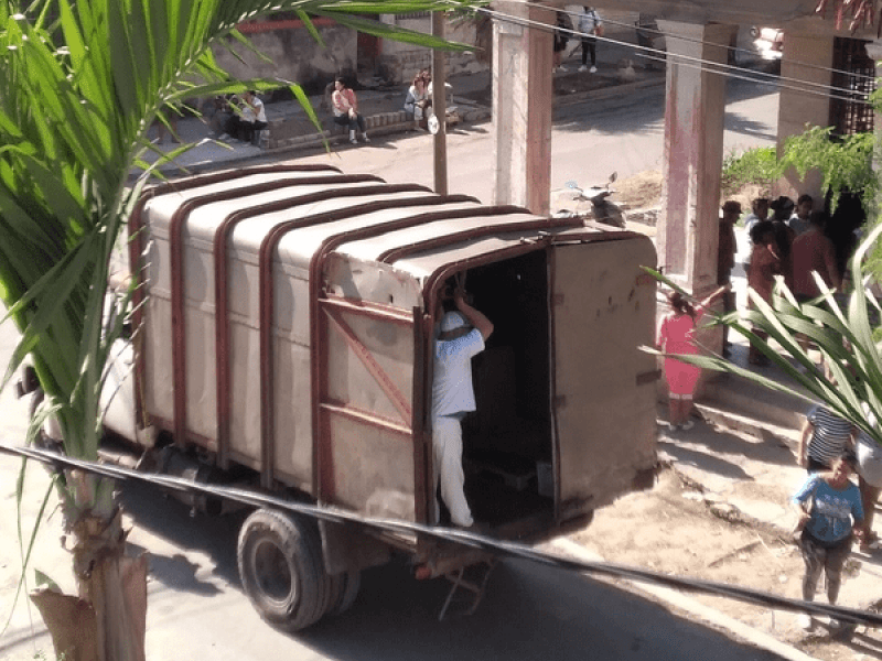 Camión en una carnicería en La Habana, Cuba. Alrededor, las personas esperan por el envío de alimentos.